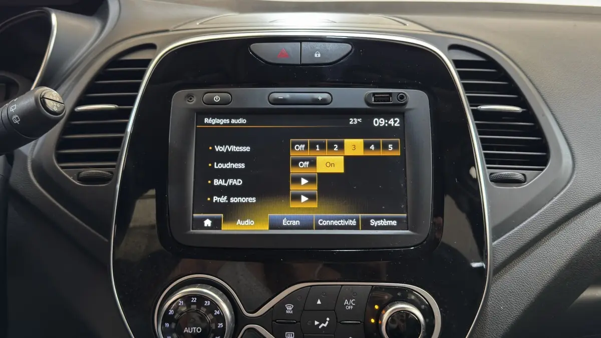 Vue rapprochée du tableau de bord noir du Renault Captur Intens TCe 90 avec écran tactile affichant les réglages audio.