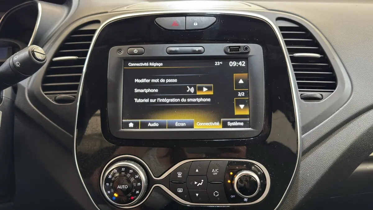 Vue rapprochée du tableau de bord noir du Renault Captur Intens 2019 avec écran tactile et commandes de climatisation.
