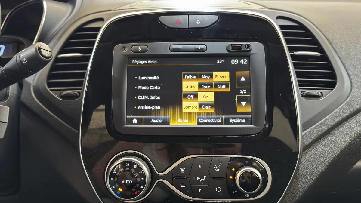 Vue rapprochée du tableau de bord noir du Renault Captur Intens 2019 avec écran tactile et commandes climatisation.