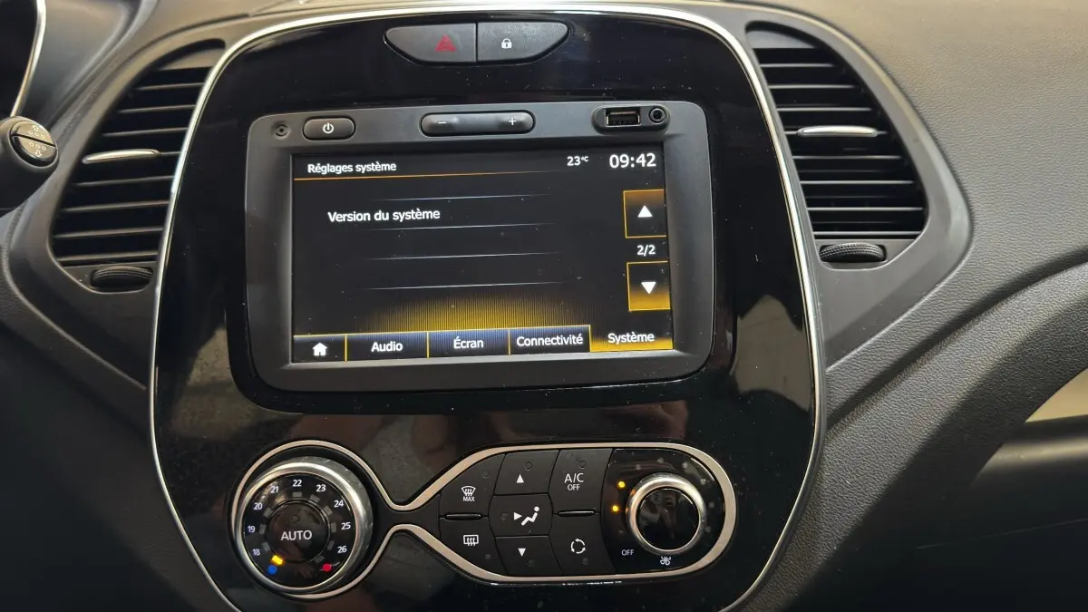 Gros plan sur l'écran tactile central et la console de climatisation du tableau de bord du Renault Captur blanc Intens TCe 90.