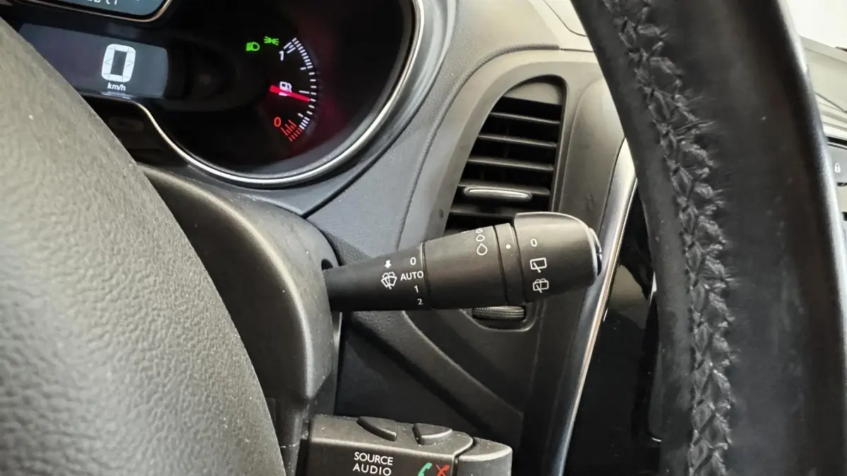 Gros plan intérieur sur le volant cuir noir et la commande d’essuie-glace du Renault Captur blanc Intens TCe 90 2019.