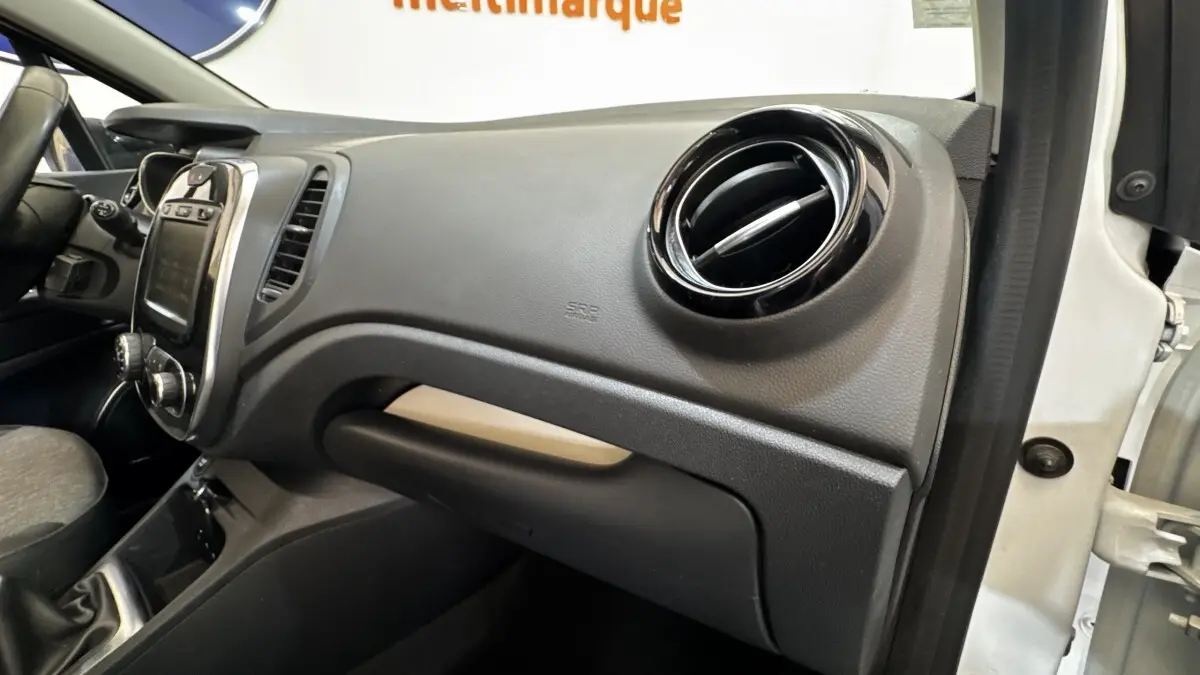 Vue intérieure côté passager du tableau de bord noir du Renault Captur blanc Intens TCe 90 de 2019.
