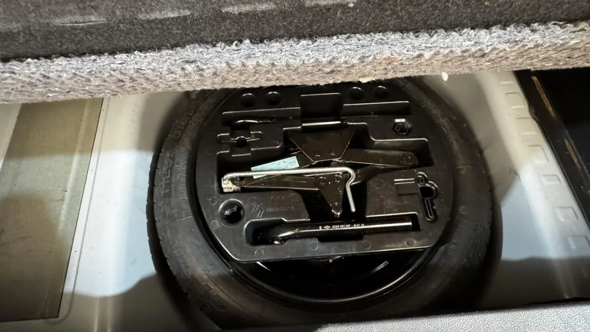 Vue rapprochée du coffre du Renault Captur blanc 2019 montrant la roue de secours et les outils de changement de pneu.