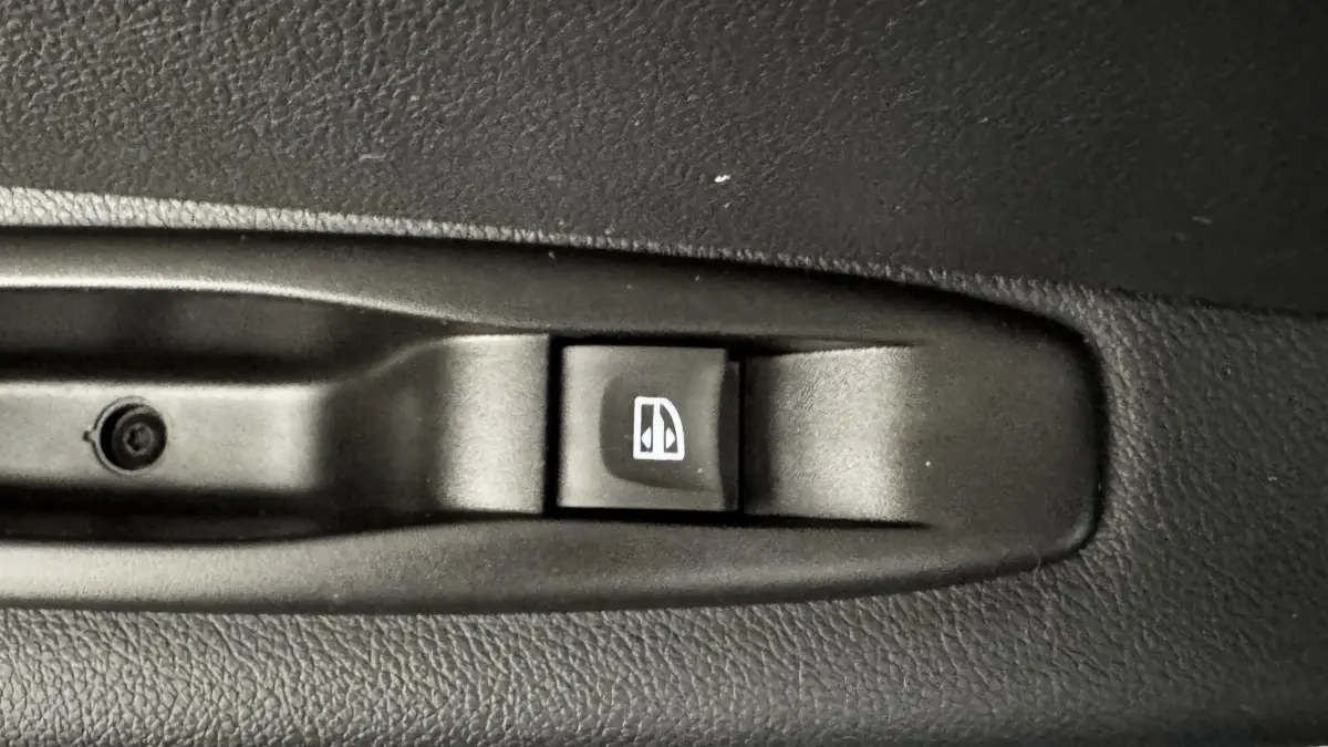 Gros plan sur l'interrupteur de lève-vitre noir dans l'habitacle d'un Renault Captur blanc Intens TCe 90.