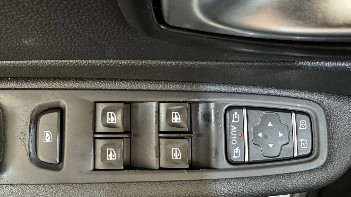 Gros plan sur les commandes des vitres et rétroviseurs côté conducteur d’un Renault Captur blanc 2019 Intens TCe 90.