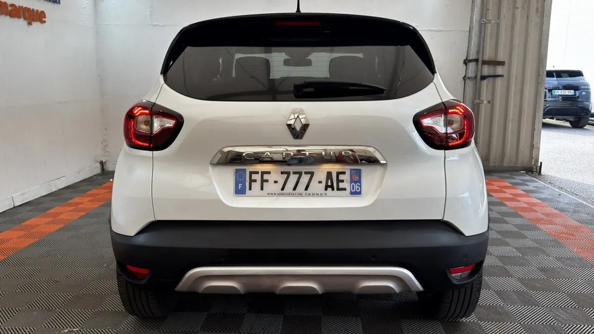 Vue arrière d'un Renault Captur blanc 2019 avec feux LED et plaque d'immatriculation française visible.
