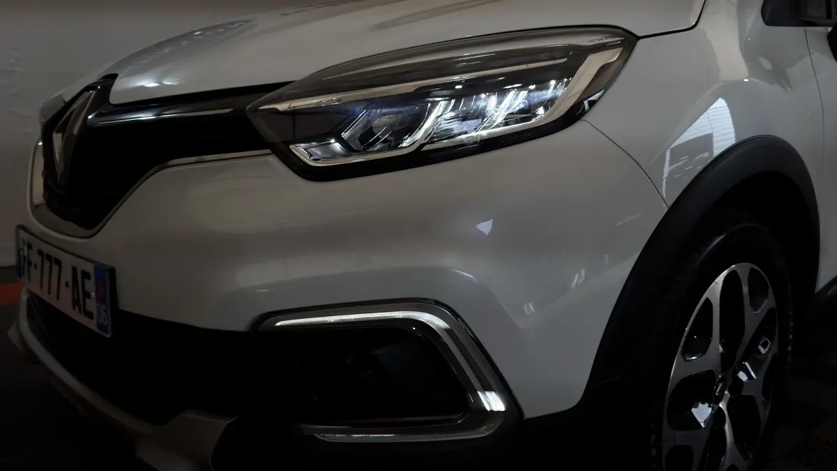 Gros plan sur l'avant droit blanc du Renault Captur Intens 2019, mettant en valeur le phare LED et la calandre.