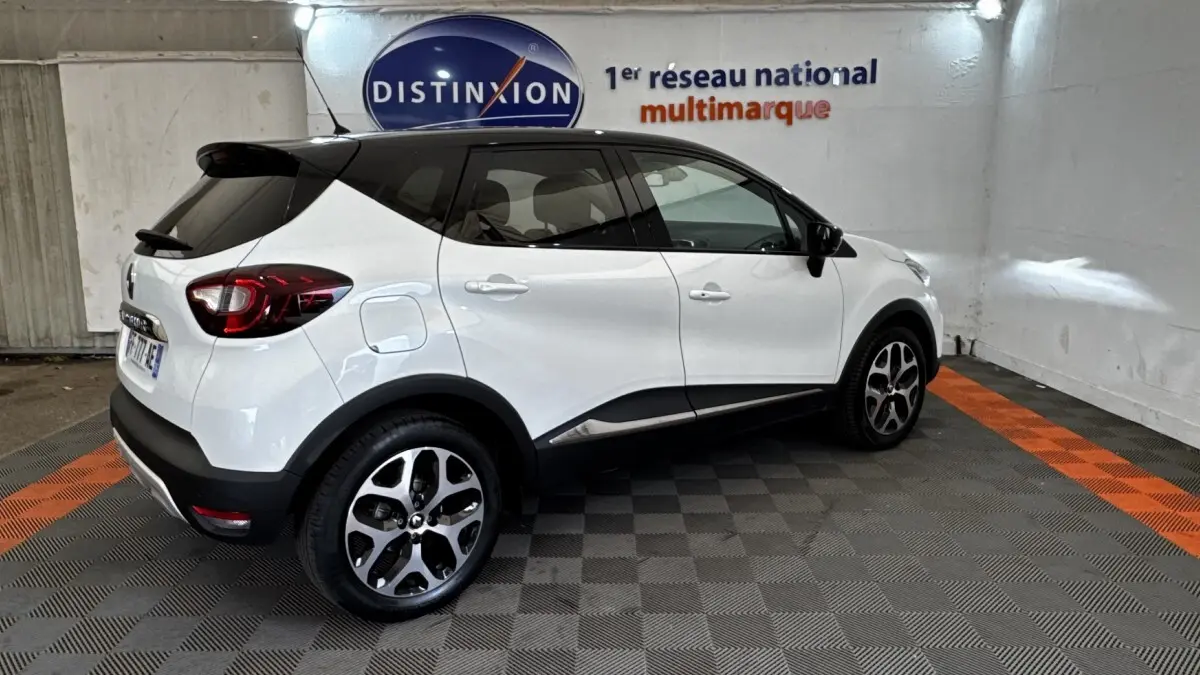 Renault Captur Intens blanc vu de profil droit, avec toit noir et jantes alliage distinctives.