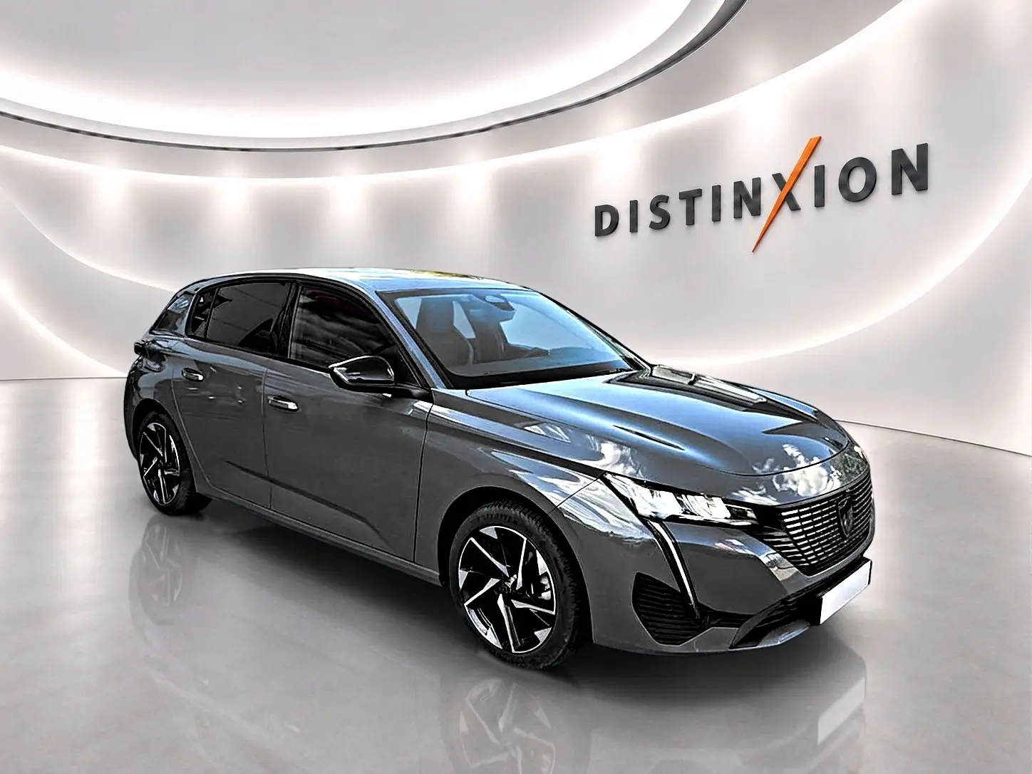 Peugeot 308 gris selenium vue 3/4 avant droit avec jantes alliage et calandre noire distinctive.