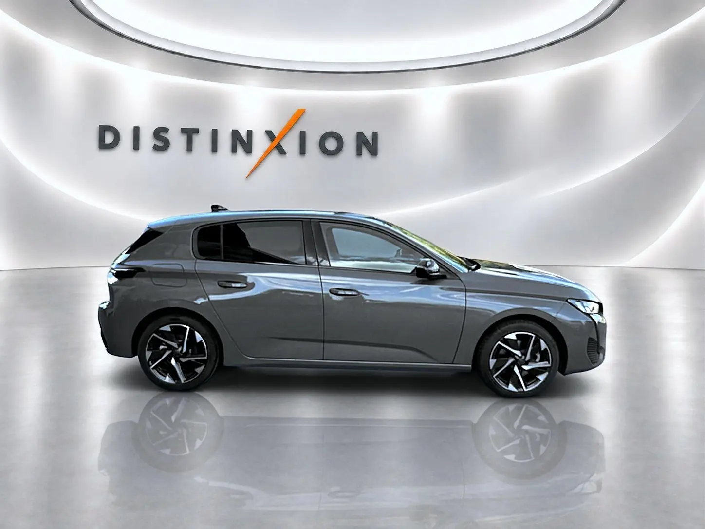 Profil droit d'une Peugeot 308 gris selenium 2025 dans un showroom avec jantes alliage et vitres surteintées.