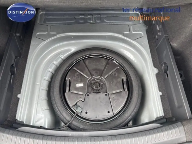 Roue de secours dans le coffre d'une CUPRA Leon 2024 gris magnétique mat, vue plongeante sur le compartiment vide.