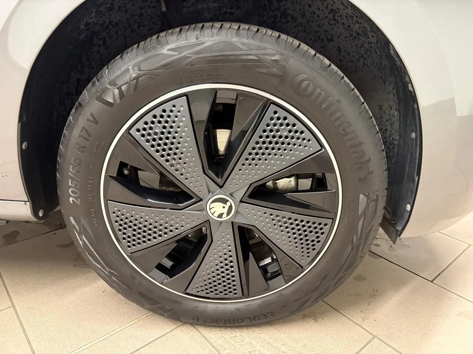 Gros plan sur la roue avant gauche du Skoda Kamiq 2024 gris graphite, avec jante noire et détails perforés Monte Carlo.