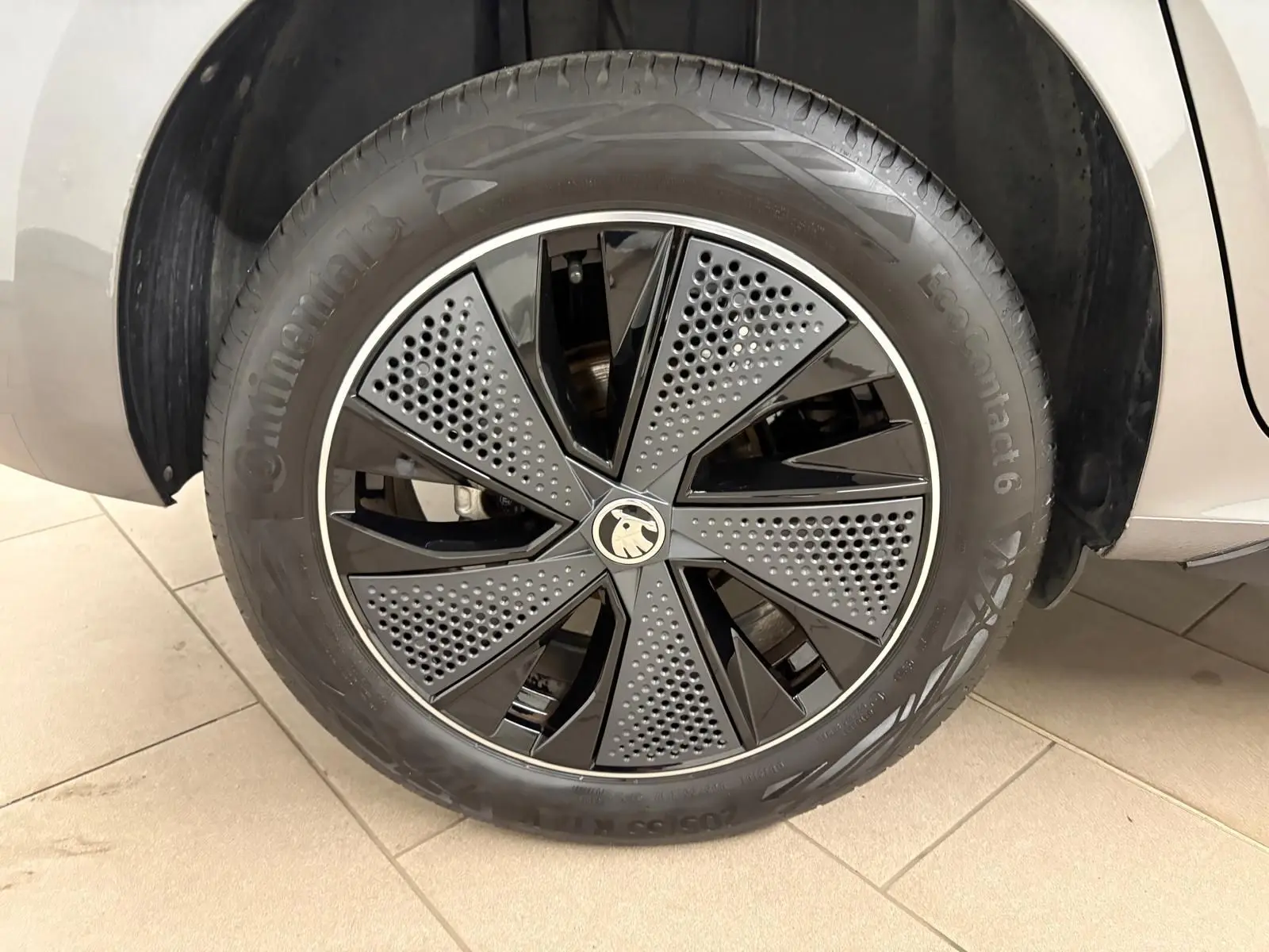 Gros plan sur la roue avant gauche du Skoda Kamiq Monte Carlo 2024 gris graphite avec jante noire et grise au design perforé.