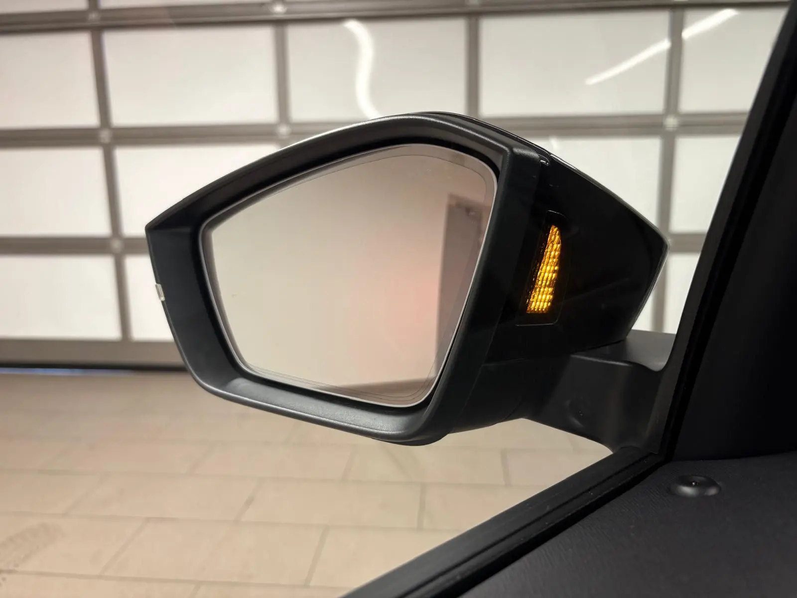 Rétroviseur extérieur droit du Skoda Kamiq 2024 gris graphite avec clignotant allumé, vue rapprochée intérieure.