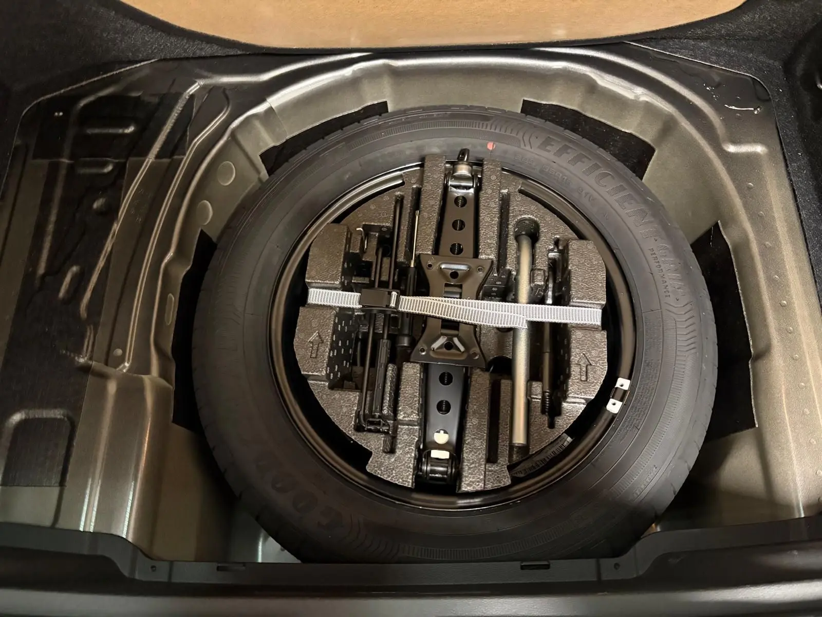 Vue plongeante sur la roue de secours et les outils de bord dans le coffre du Skoda Kamiq 1.5 TSI 150 DSG7 Monte Carlo gris graphite 2024.