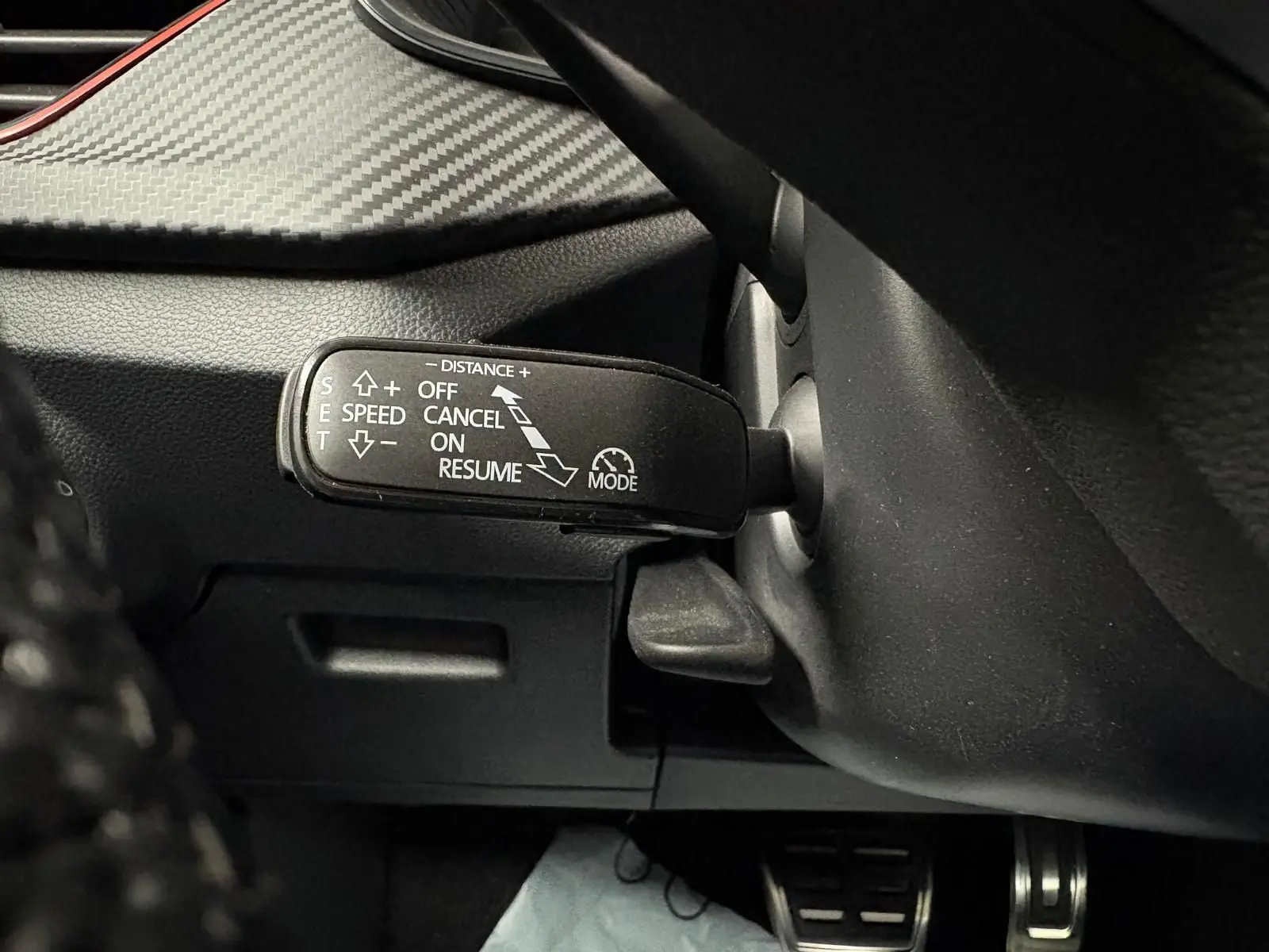 Gros plan sur la commande de régulateur de vitesse du Skoda Kamiq 1.5 TSI 150 DSG7 Monte Carlo gris graphite, intérieur noir.