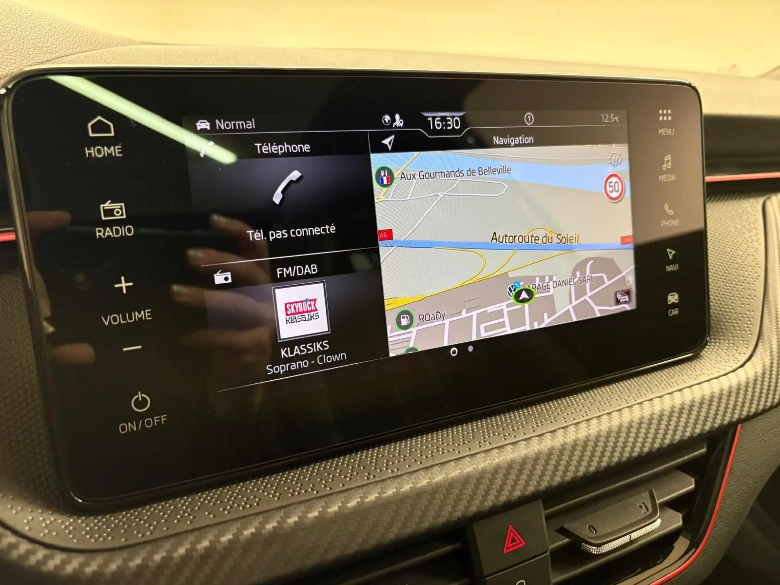 Écran tactile central du Skoda Kamiq Monte Carlo 2024 avec navigation et interface multimédia en vue rapprochée.