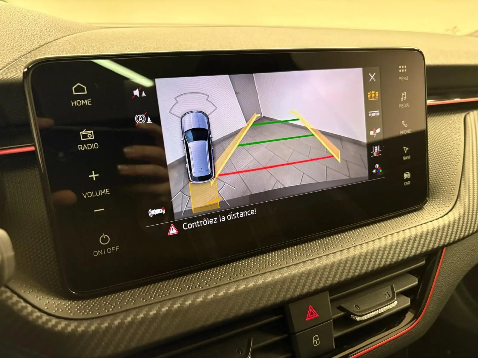 Écran tactile intérieur du Skoda Kamiq 2024 montrant la caméra de recul avec guidage de trajectoire en gris graphite.