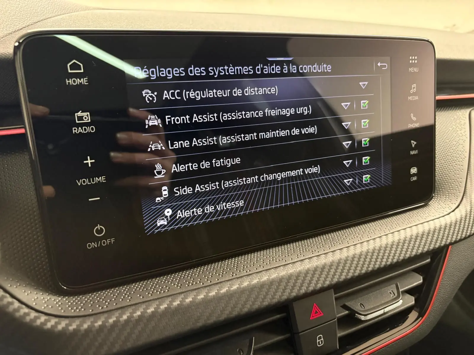 Écran tactile central du Skoda Kamiq Monte Carlo 2024 montrant les réglages des aides à la conduite, avec finition gris graphite.