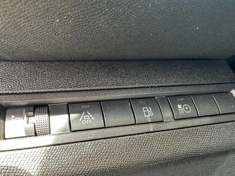 Gros plan sur les commandes noires du tableau de bord du Peugeot 3008 hybride rechargeable 2024, finition Allure.
