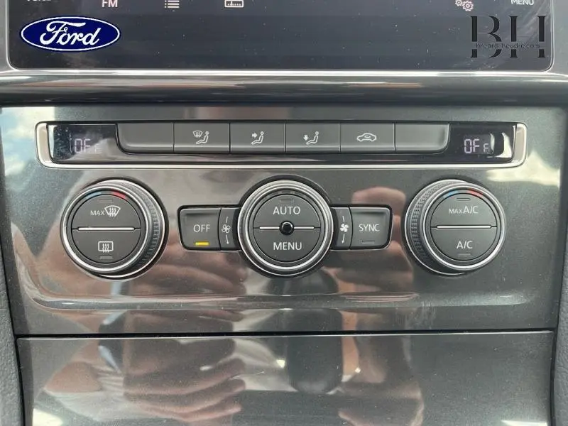Gros plan sur la console centrale du Volkswagen Golf SW 2019, boutons de climatisation automatique et réglages d'air.