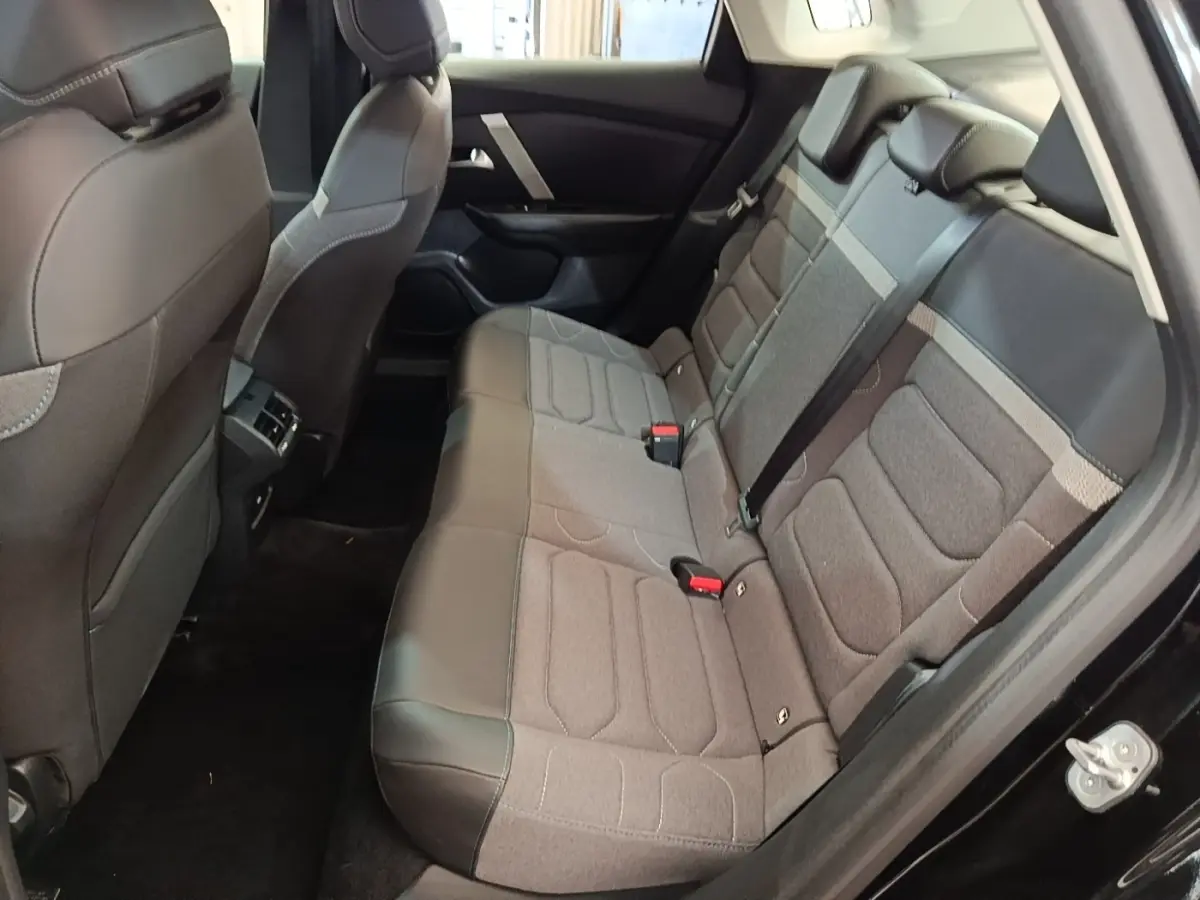 Vue intérieure côté droit des sièges arrière gris et noir d'une Citroën C4 X noire, avec ceinture de sécurité visible.