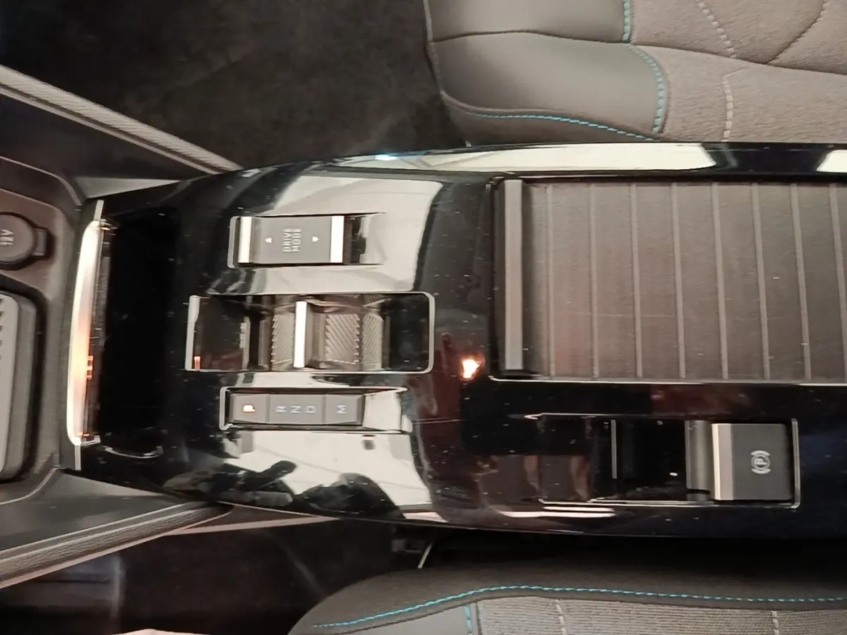 Vue plongeante sur la console centrale noire brillante de la Citroën C4 X avec commandes de boîte automatique et frein électrique.