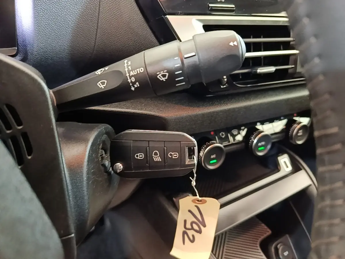 Gros plan sur la commande des essuie-glaces et le tableau de bord noir intérieur d'une Citroën C4 X 2023.