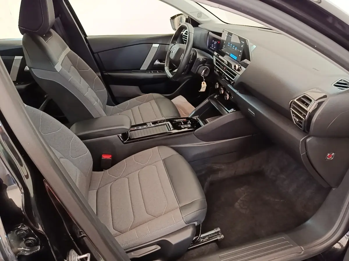 Intérieur de la Citroën C4 X noir, vue côté droit, avec sièges tissu-cuir et tableau de bord digital.
