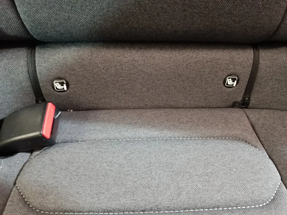 Détail de la banquette arrière grise avec fixation Isofix et boucle de ceinture visible dans une Citroën C4 X noire.