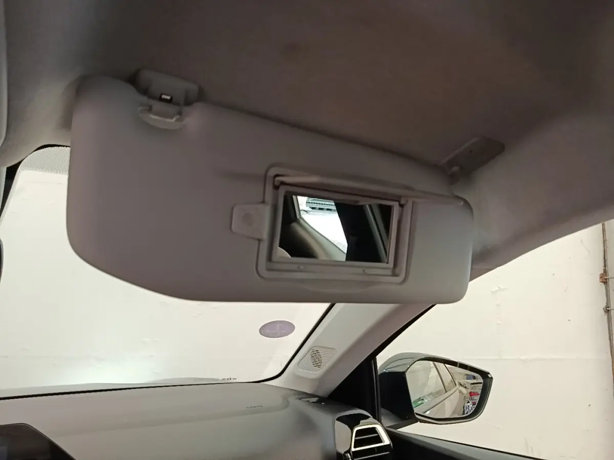 Intérieur de la Citroën C4 X noir, vue du pare-soleil avec miroir et rétroviseur côté droit visible.