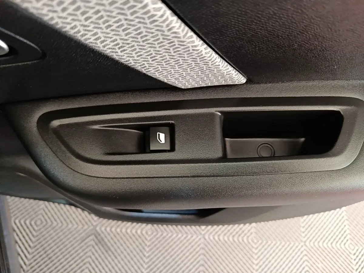 Détail de la commande de lève-vitre sur la porte intérieure d'une Citroën C4 X noire.