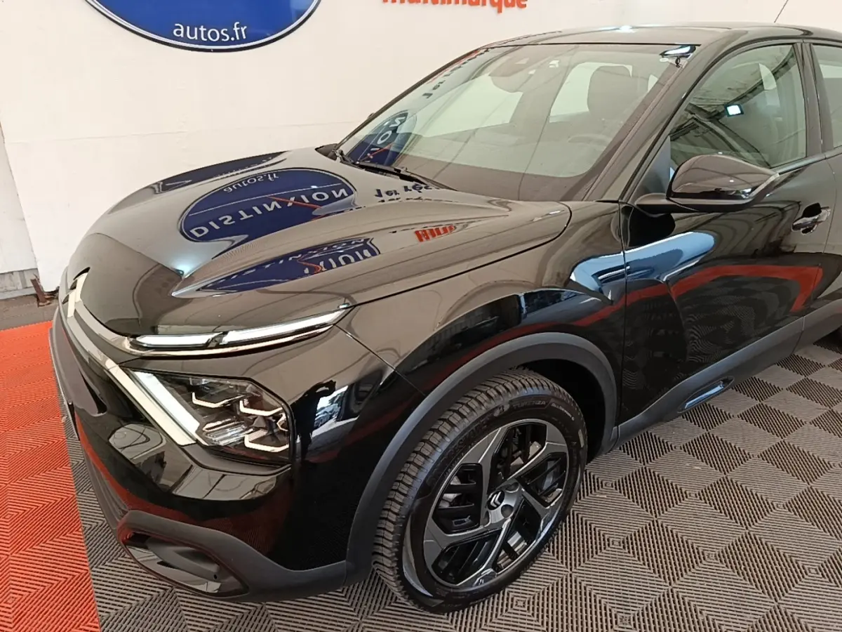Vue 3/4 avant droit de la Citroën C4 X noire 2023 avec phares LED et jantes alliage distinctives.