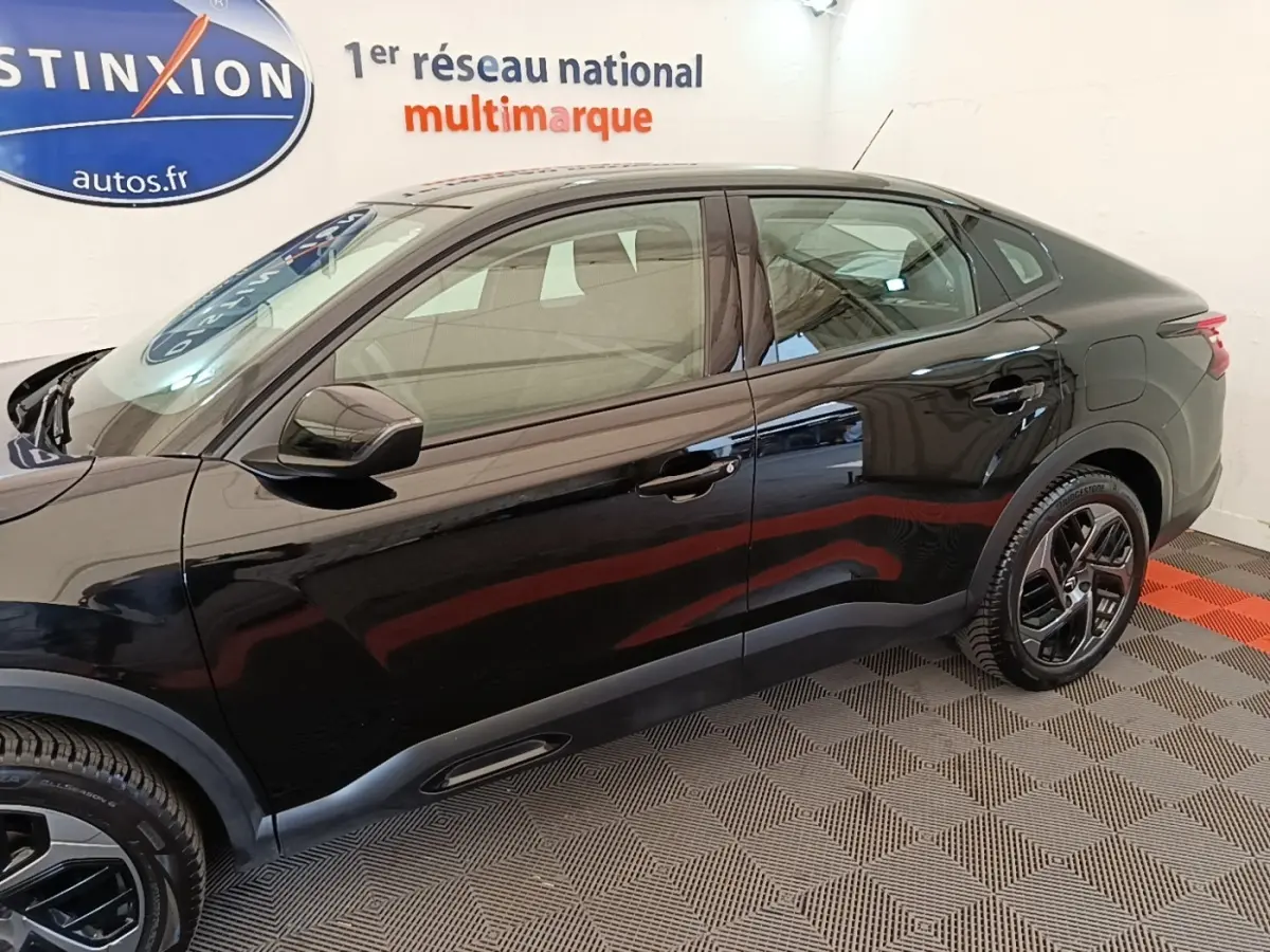 Vue côté gauche de la Citroën C4 X noire 2023, finition Feel Pack, avec jantes alliage et lignes fluides.