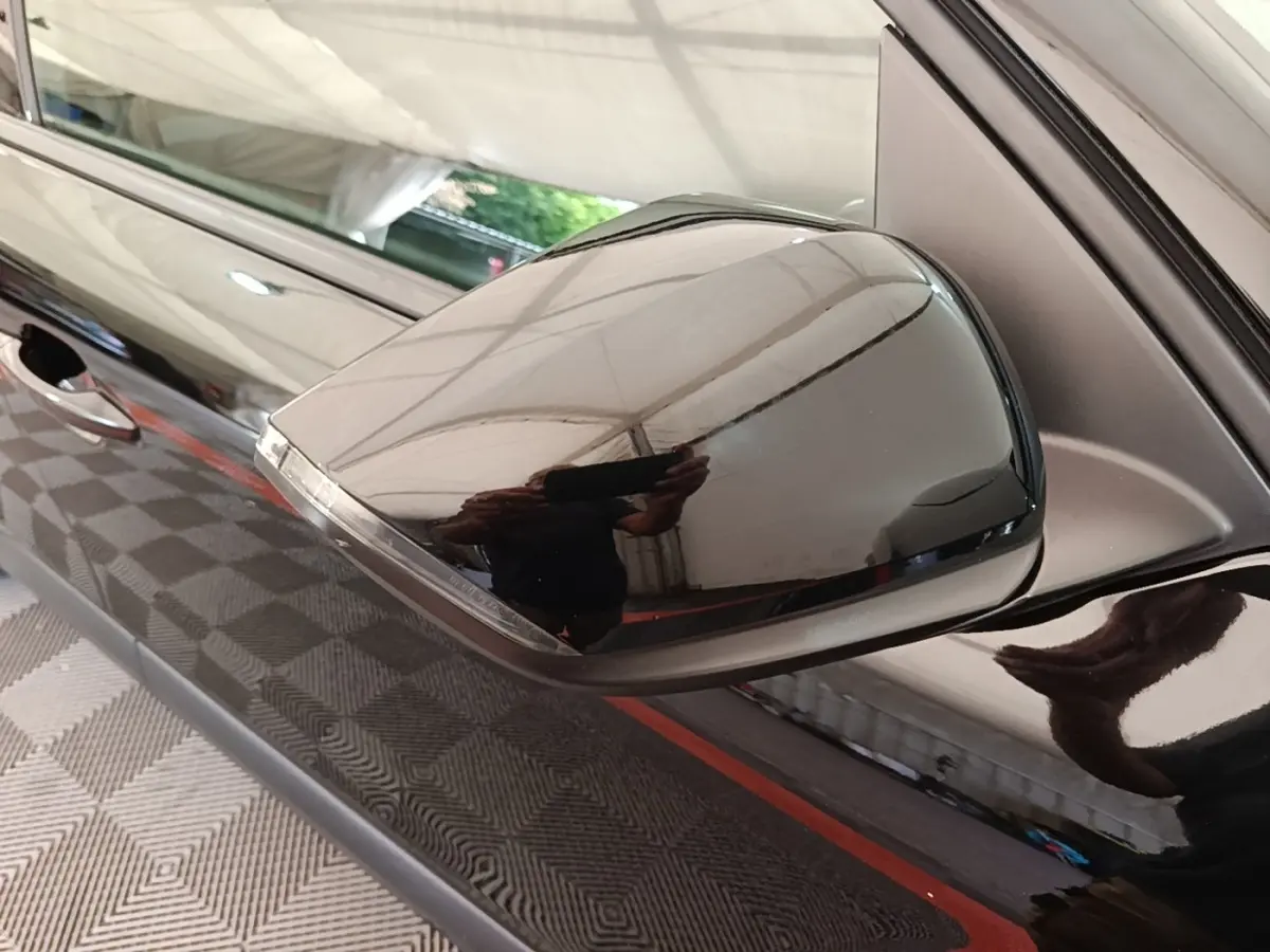 Rétroviseur côté gauche noir brillant de la Citroën C4 X PureTech 130, avec poignée de porte visible en arrière-plan.