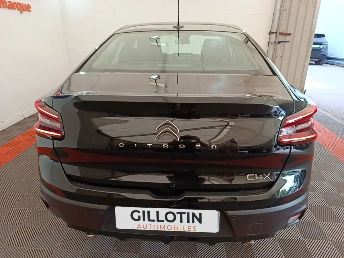 Vue arrière d'une Citroën C4 X noire 2023 avec feux LED distinctifs et logo centré sur le coffre.