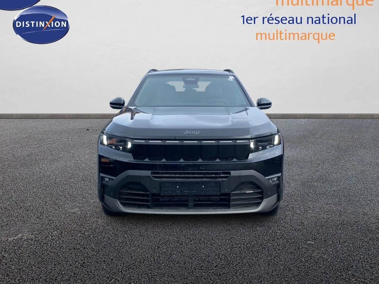 Vue frontale d'un Jeep Compass noir Vulcano métal avec calandre noire et phares LED allumés.