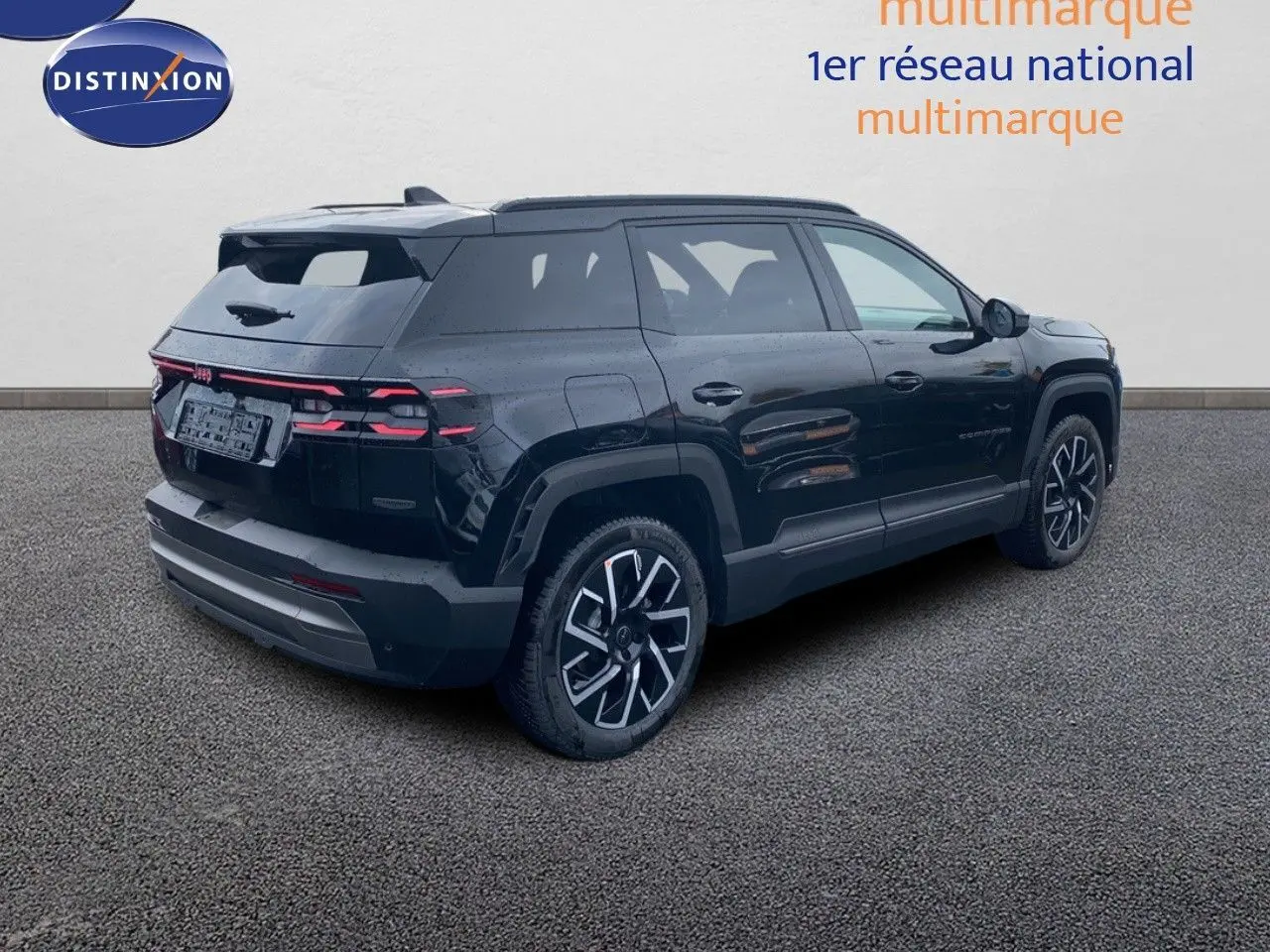 Jeep Compass noir Vulcano métal vu en 3/4 arrière côté droit, soulignant ses jantes et feux arrière LED distinctifs.