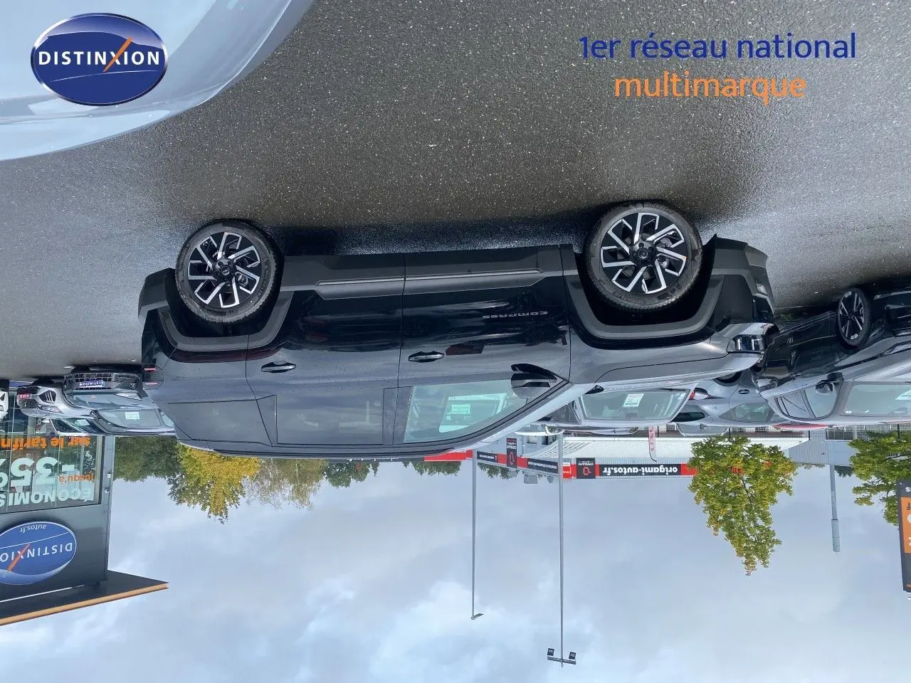 Jeep Compass noir Vulcano métal vu de profil côté gauche sur parking extérieur avec jantes alliage bicolores.