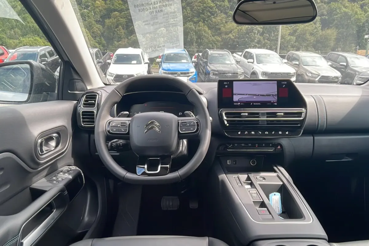 Intérieur du Citroën C5 Aircross Hybrid 2025, vue frontale du poste de conduite avec volant multifonction et écran tactile.