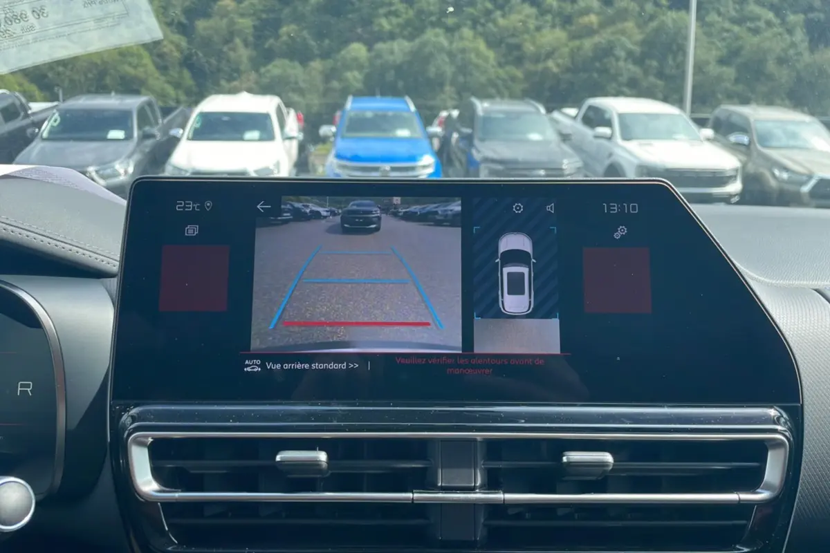 Écran central montrant la caméra de recul d'un Citroën C5 Aircross Hybrid blanc, vue arrière avec lignes de guidage colorées.