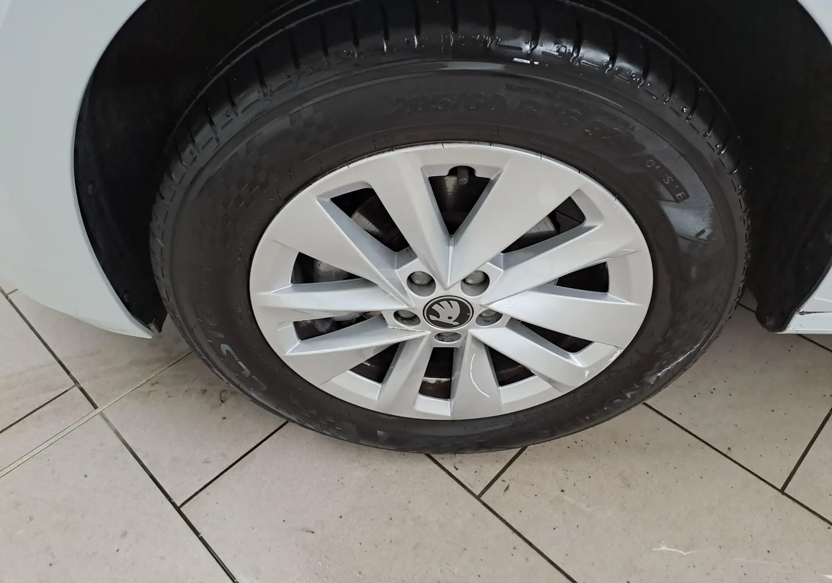 Gros plan sur la roue avant droite blanche Lune d’un Skoda Kamiq 2025 avec jante alliage au design à rayons.