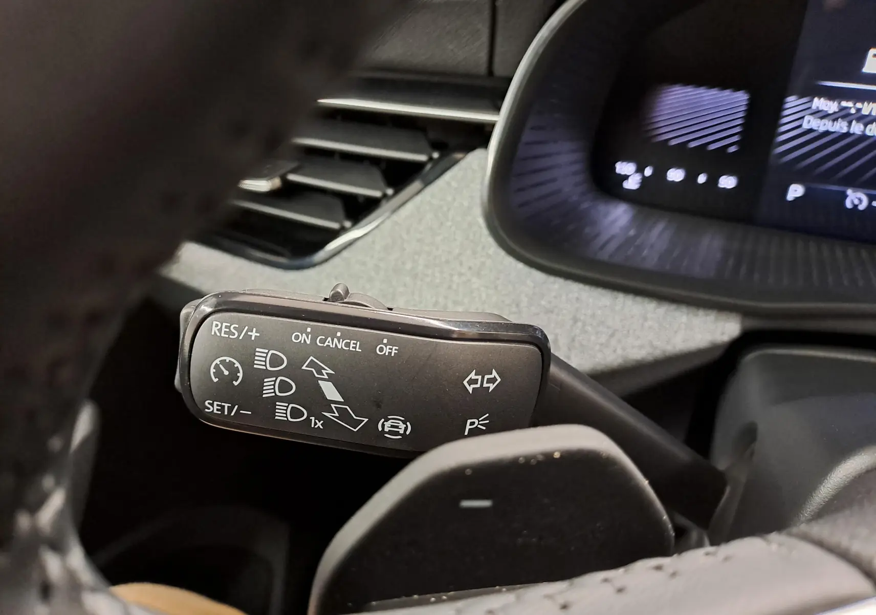 Gros plan sur la commande de régulateur de vitesse du Skoda Kamiq blanc Lune, intérieur côté conducteur.
