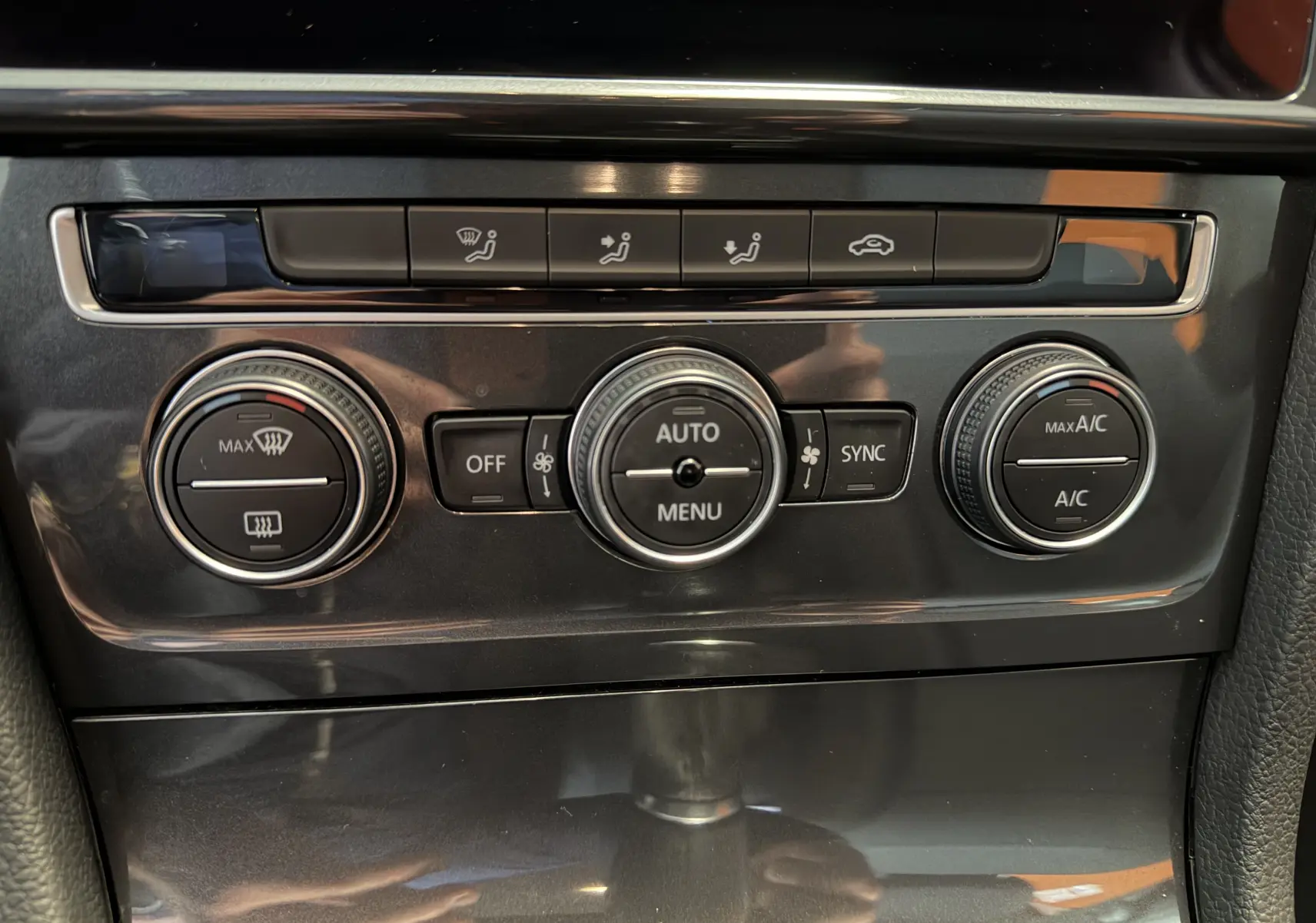 Détail de la console centrale avec commandes de climatisation automatique sur Volkswagen Golf TSI 130 Confortline gris 2019.