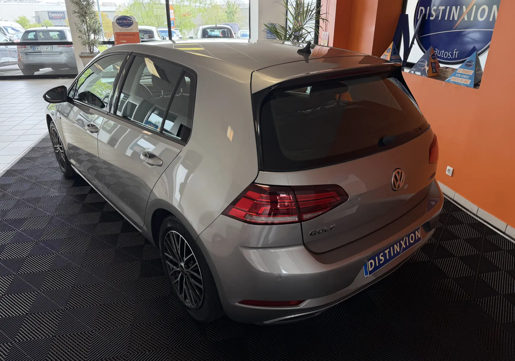 Volkswagen Golf TSI 130 Confortline gris vue 3/4 arrière droit en intérieur avec jantes alliage et vitres teintées.