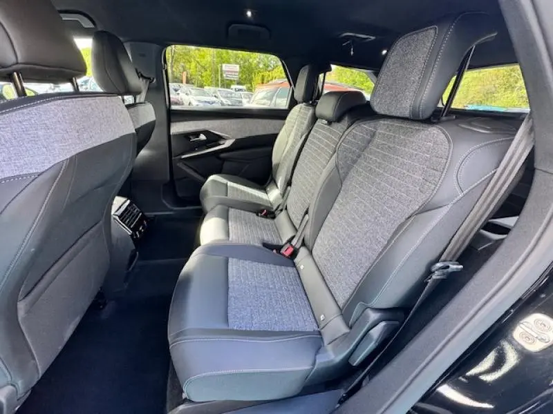 Vue intérieure côté droit des sièges arrière en tissu gris et cuir noir du Peugeot 5008 Hybrid 2025, avec 2 sièges supplémentaires.
