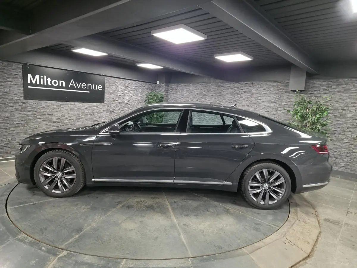 Volkswagen Arteon gris en profil droit, avec jantes alliage 18" et badge R-Line visible sur les portes.