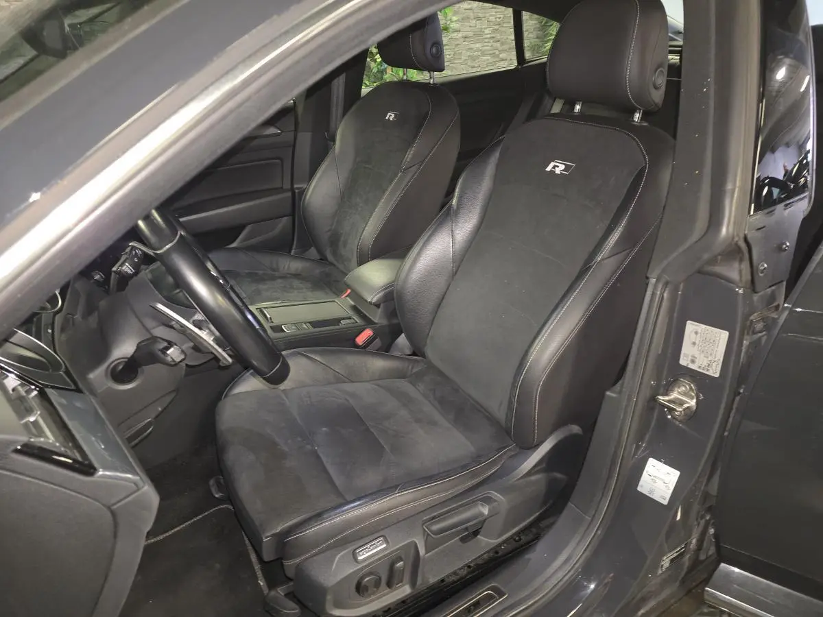 Vue intérieure côté conducteur du Volkswagen Arteon gris, sièges sport en cuir noir avec logo R brodé.