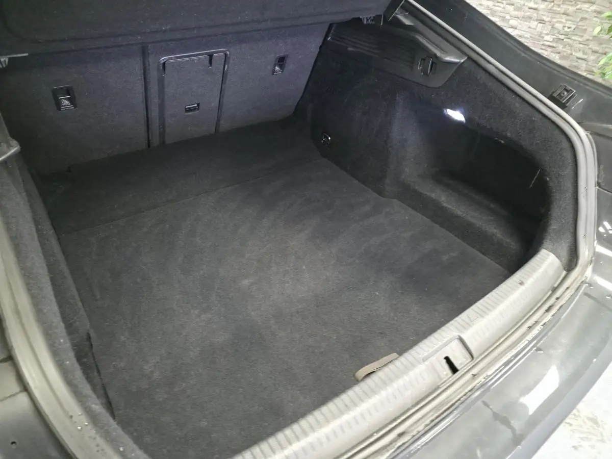 Coffre ouvert vu de dessus d’un Volkswagen Arteon gris 2020, intérieur noir avec éclairage latéral LED.