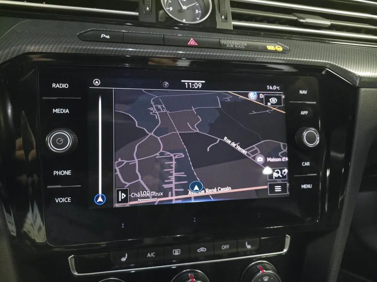 Écran tactile central du Volkswagen Arteon 2020 gris, affichant la navigation GPS avec horloge analogique au-dessus.